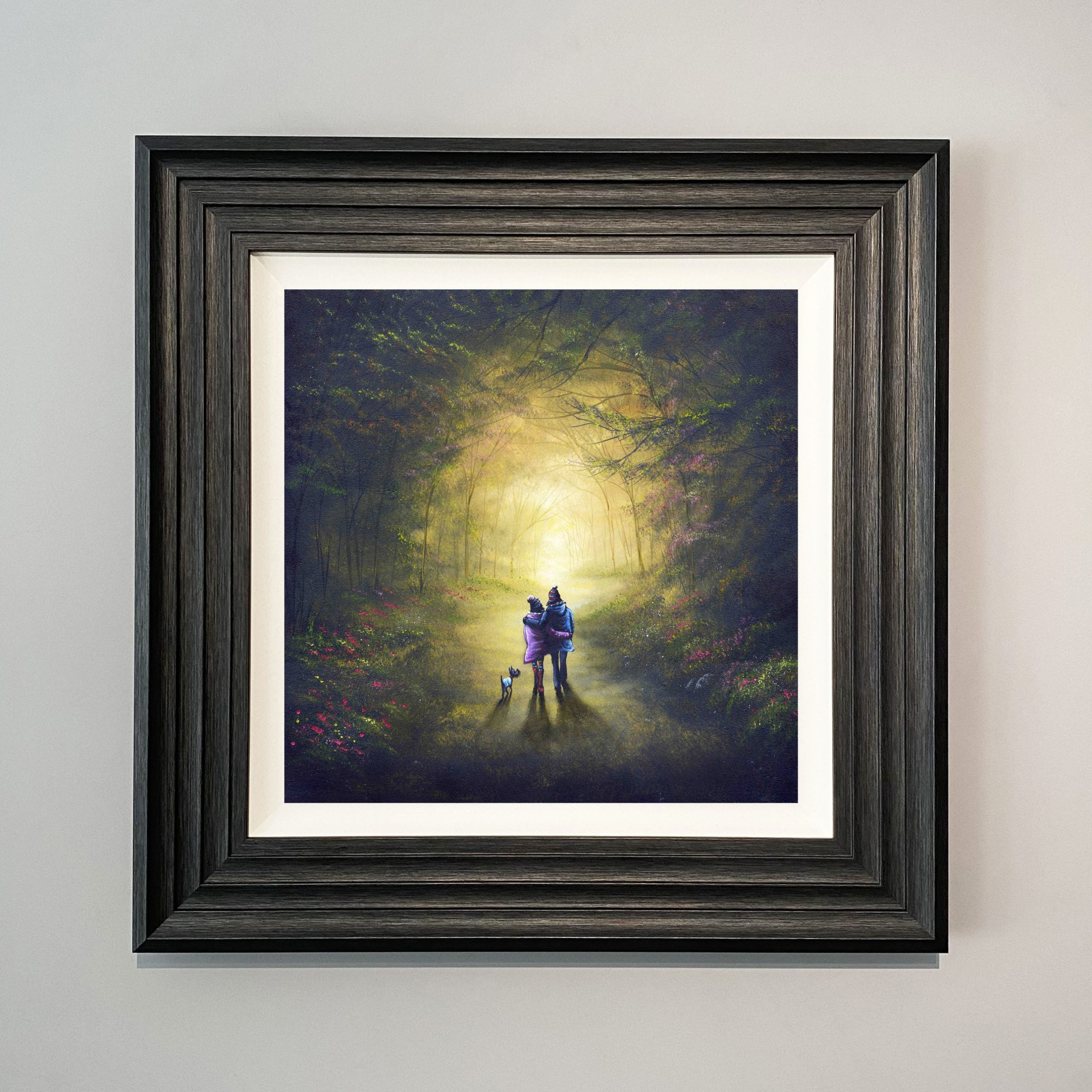 Couple and a dog walking together through a magical glowing woodland path surrounded by trees 