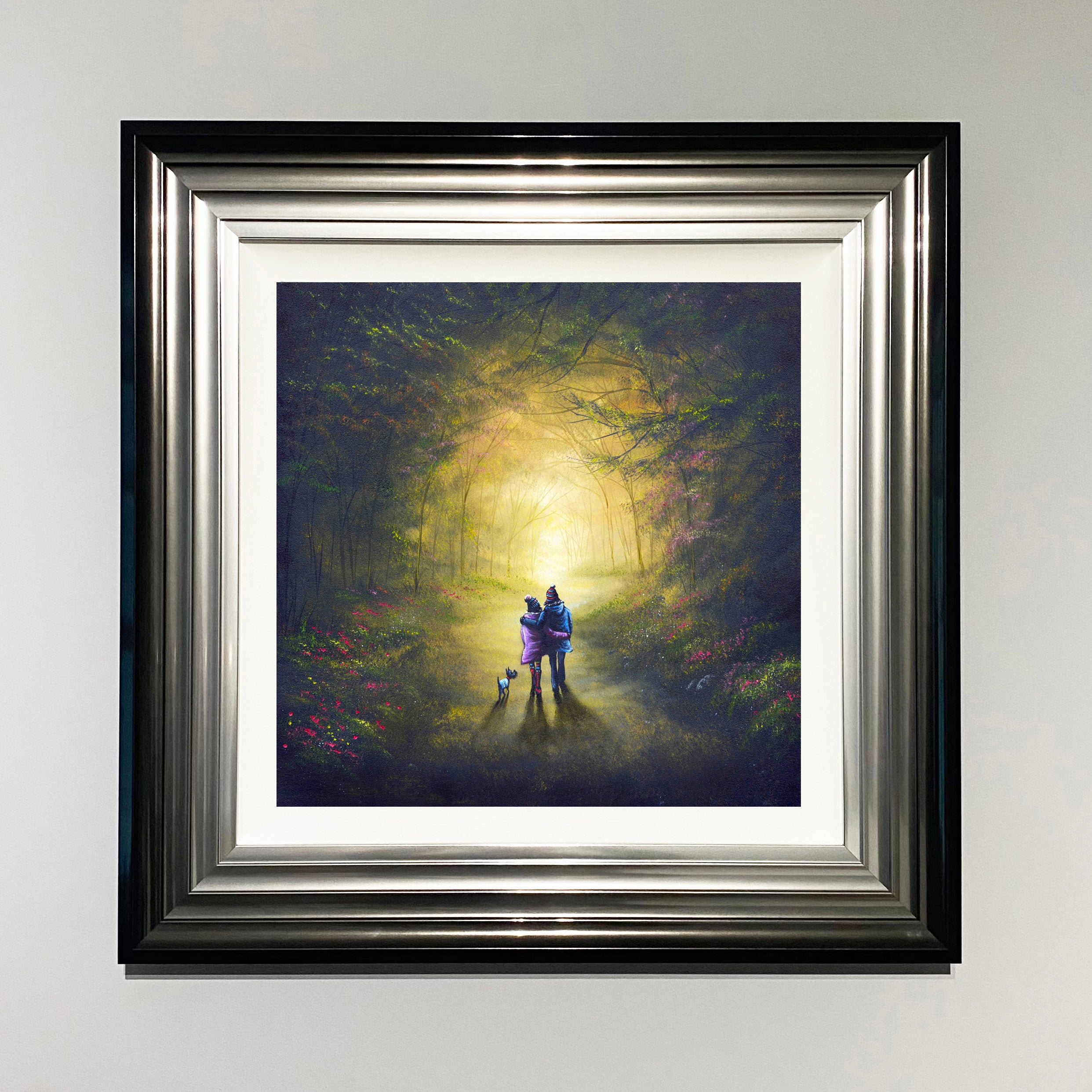 Couple and a dog walking together through a magical glowing woodland path surrounded by trees 