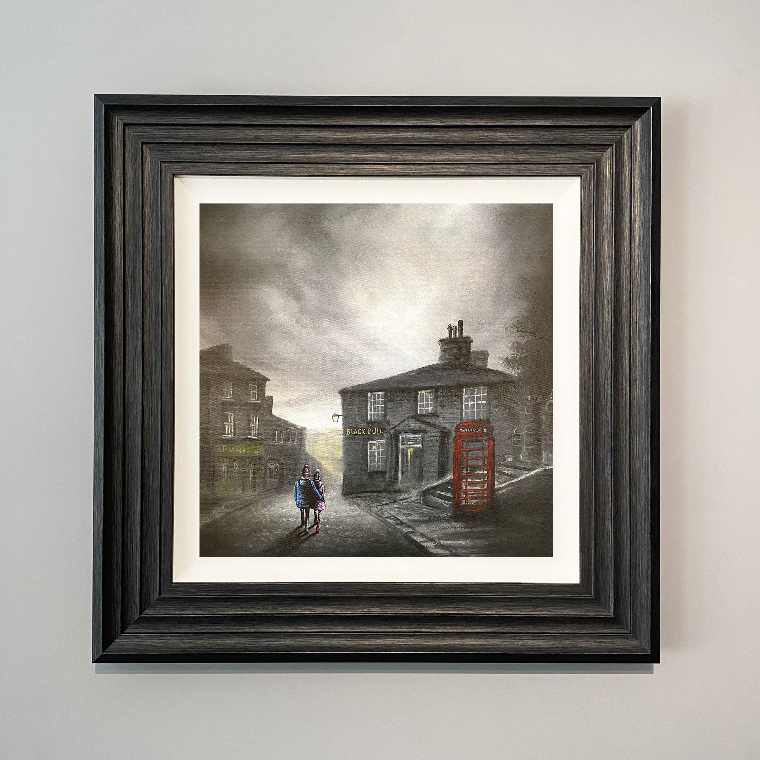 A Stroll Down The Cobbles Landscape art print of Haworth Main Street Yorkshire showing a couple walking past the Black Bull pub by Danny Abrahams