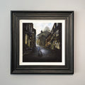 By'Eck Its An Uphill Struggle shows a Yorkshire man pushing a bike up Haworth Main Street cobbles landscape art print by Danny Abrahams 